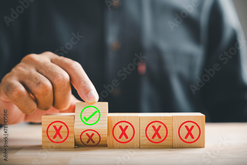 Foto Wooden cube flipped by hand, red cross to correct tick representing project approval concept