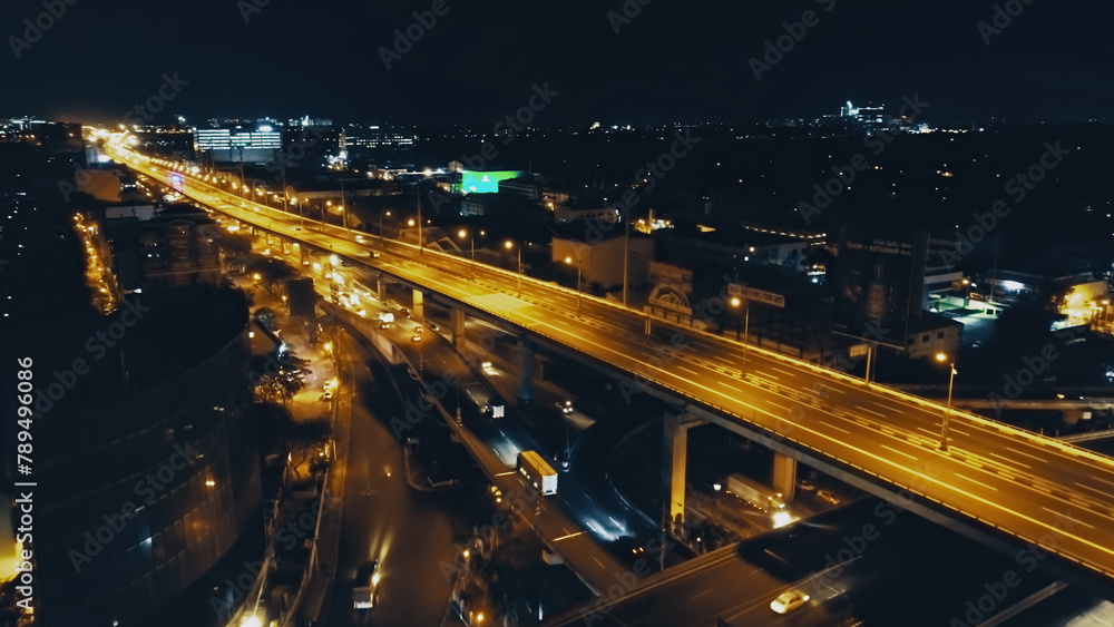 Night closeup traffic road with cars, trucks drive at night top down aerial view. Philippines capital town of Manila highway with transport ride at neon lights. Amazing illuminated cityscape drone - obrazy, fototapety, plakaty 
