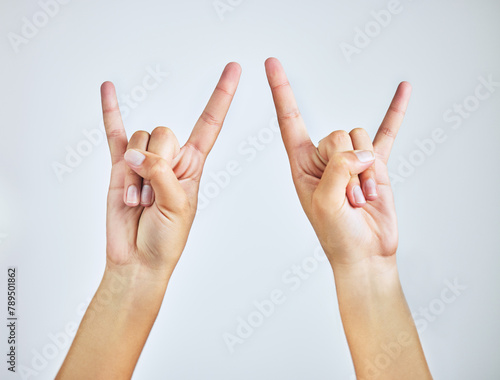 Behang Hands, closeup and person in studio with rock and roll sign, gesture or symbol on white background