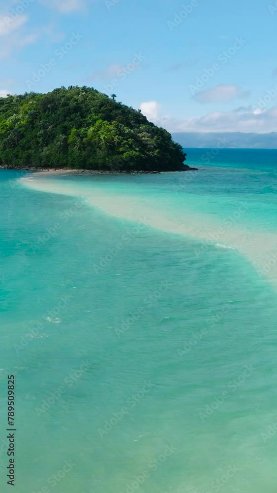 Turquoise sea water and waves around Bang-og Island. Blue sky and clouds. Romblon, Romblon. Philippines. Vertical view. Turquoise sea water and waves around Bang-og Island. Blue sky and clouds. Romblon, Romblon. Philippines. Vertical view.