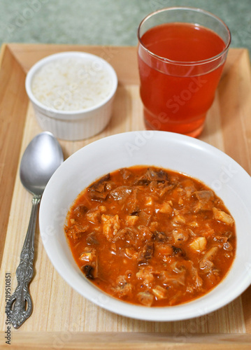 Comida tradicional Guatemalteca llamada "Revolcado", hecha de cerdo, servida con arroz blanco y refresco de fresa. Toma Vertical.