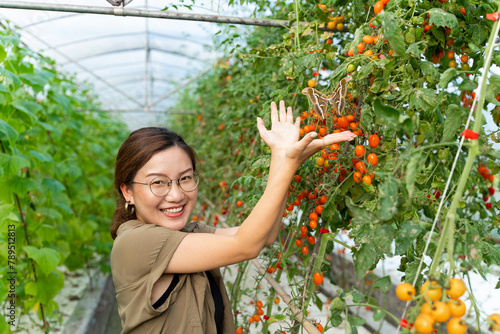 asian woman looking at big butterfly at summer farm photo