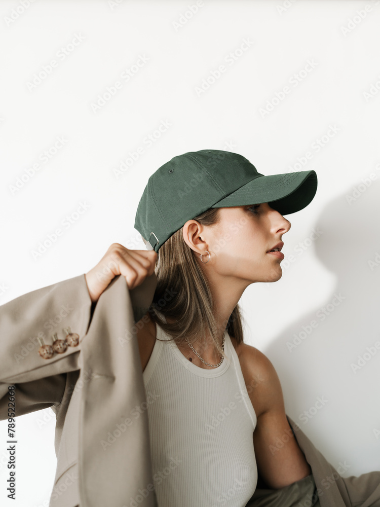 Stylish Young Woman Wearing A Blazer And Hat In Front Of Backdrop Stylish Young Woman Wearing A Blazer And Hat In Front Of Backdrop