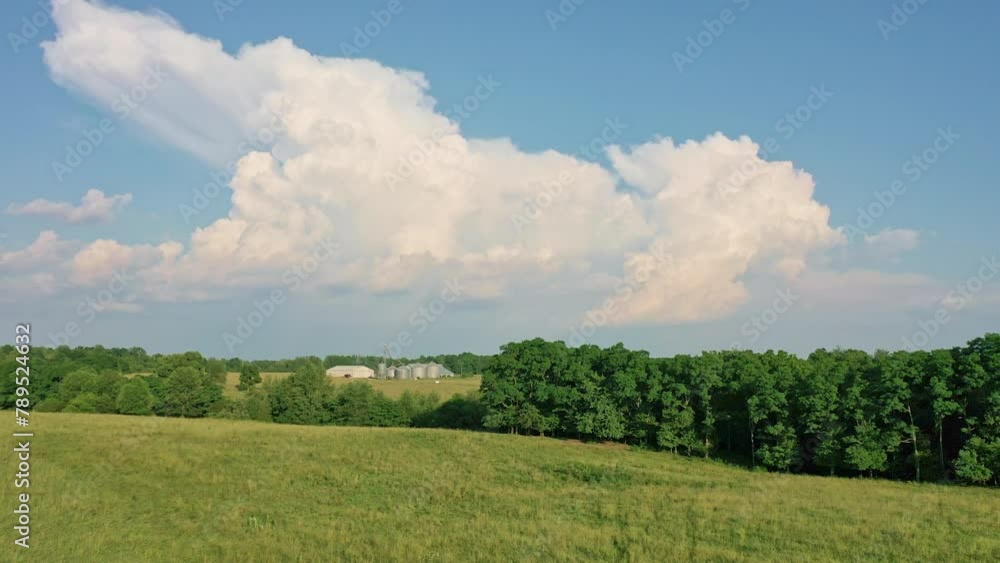 Wide angle of a working farm with a barn and silos in the background Wide angle of a working farm with a barn and silos in the background