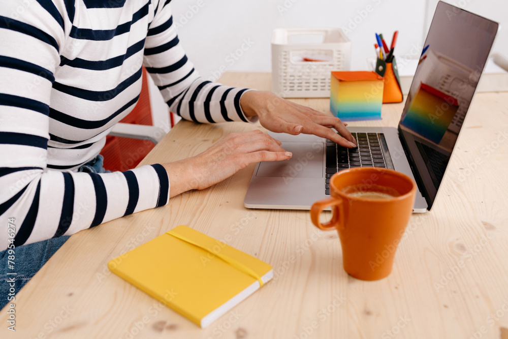 © Tania Cervian/Stocksy - Faceless woman using laptop at workplace © Tania Cervian/Stocksy - Faceless woman using laptop at workplace