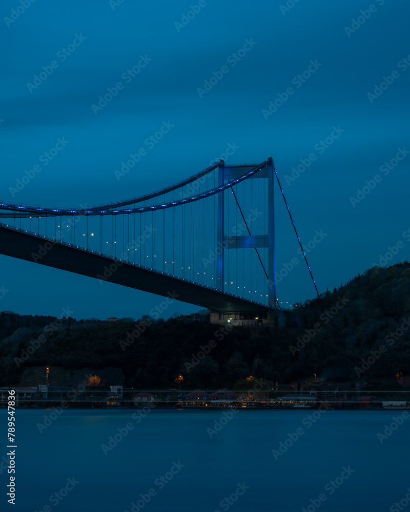 Naklejka premium View of suspension bridge against cloudy sky