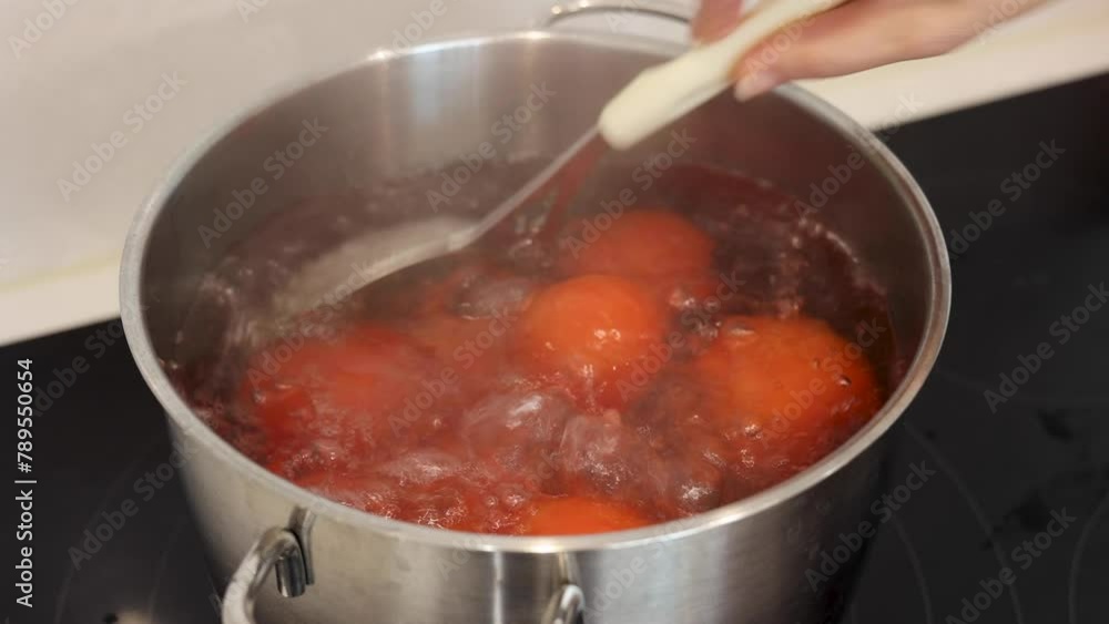 Boiling tomatoes, lifting boiled tomatoes with a ladle Boiling tomatoes, lifting boiled tomatoes with a ladle