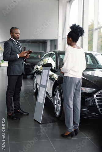 Anonymous customer attentive employee discuss vehicle purchase terms photo