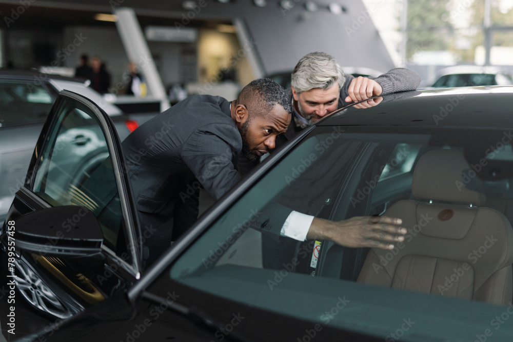 Customer advisor demonstrating car features dealership Customer advisor demonstrating car features dealership