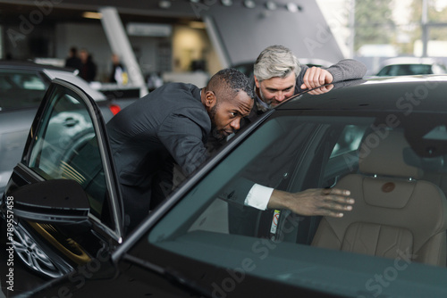 Customer advisor demonstrating car features dealership photo