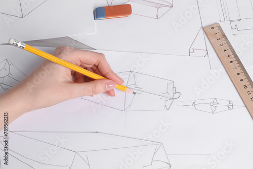 Woman creating packaging design at table, top view
