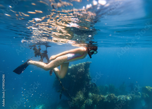 Woman snorkeling next to a sunken ship photo