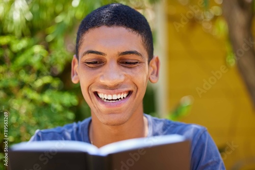 Book, man and reading outdoor with joy for university exam with notebook learning and smile in garden. Study, journal and college student happy from education and relax in the backyard of a home