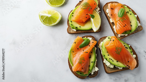 Avocado toasts with salmon fish on grey background, copy space. Healthy breakfast, top view