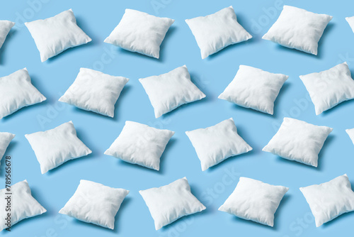 Seamless pattern of white soft pillows repeating on blue background photo