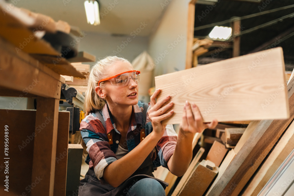 In a bustling carpenter's shop, a young woman craftsman expertly navigates her workshop, merging traditional woodwork skills with modern equipment to create hand-made furniture In a bustling carpenter's shop, a young woman craftsman expertly navigates her workshop, merging traditional woodwork skills with modern equipment to create hand-made furniture