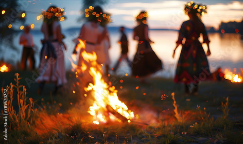 People dancing around a Midsummer Bonfire wearing traditional wreaths on their heads. Midsummer celebration concept. photo