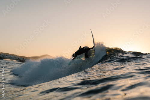 A professional surfer performing a reentry while riding a wave photo