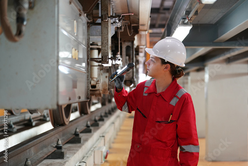 Professional technician worker hold light tube to check and maintenance part of train in electrical or metro train factory.