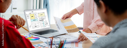 Cropped image of interior designer team discuss the material color while laptop displayed website wireframe designs for mobiles app and website. Creative design and business concept. Variegated. photo