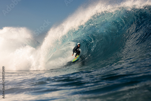 A skilled professional surfer deftly riding a colossal wave photo