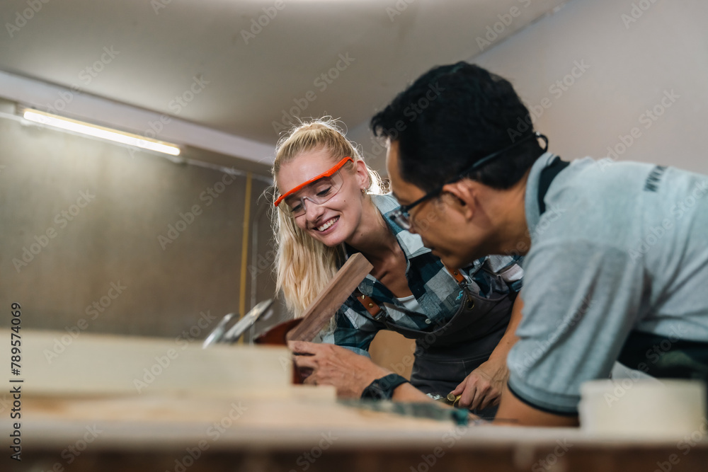 Carpenter working with electric planer on wooden plank in workshop. Craftsman makes own successful small business, man using tool in carpenter's shop to making a furniture from wood Carpenter working with electric planer on wooden plank in workshop. Craftsman makes own successful small business, man using tool in carpenter's shop to making a furniture from wood