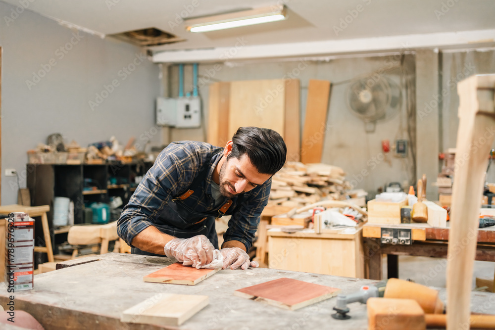 Carpenter working with electric planer on wooden plank in workshop. Craftsman makes own successful small business, man using tool in carpenter's shop to making a furniture from wood Carpenter working with electric planer on wooden plank in workshop. Craftsman makes own successful small business, man using tool in carpenter's shop to making a furniture from wood