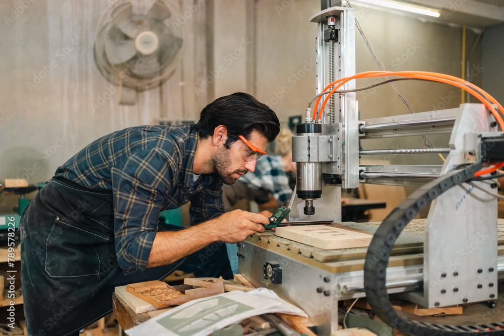 Carpenter working with electric planer on wooden plank in workshop. Craftsman makes own successful small business, man using tool in carpenter's shop to making a furniture from wood Carpenter working with electric planer on wooden plank in workshop. Craftsman makes own successful small business, man using tool in carpenter's shop to making a furniture from wood