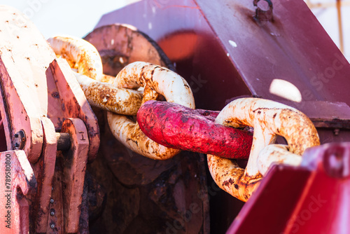 Close up view of an anchor chain of the large cargo ship. Chain at the anchor winch.