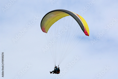 Tandem Paraglider flying in a blue sky	