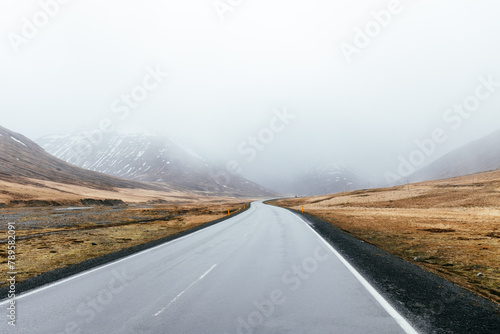 Empty road surrounded by mountains