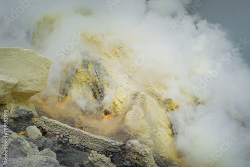 Sulfur open mine in an active volcano crater, toxic gas and ore photo