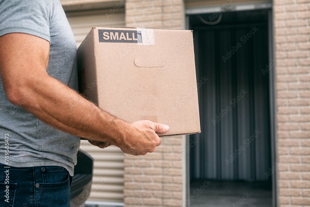 Storage: Man Putting Box Into Empty Storage Facility Storage: Man Putting Box Into Empty Storage Facility