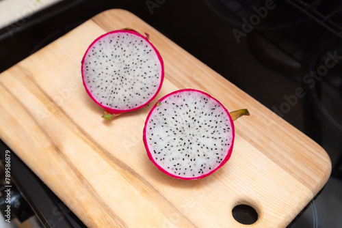 Sliced pink pitahaya fruit on wooden board. Sweet ripe dragon fruit. Exotic pitahaya tropical food