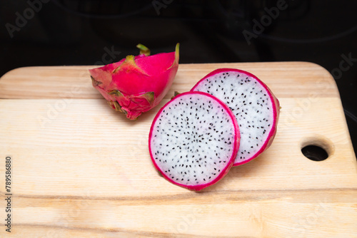 Sliced pink pitahaya fruit on wooden board. Sweet ripe dragon fruit. Exotic pitahaya tropical food
