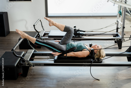 Woman doing pilates exercises in a gym photo