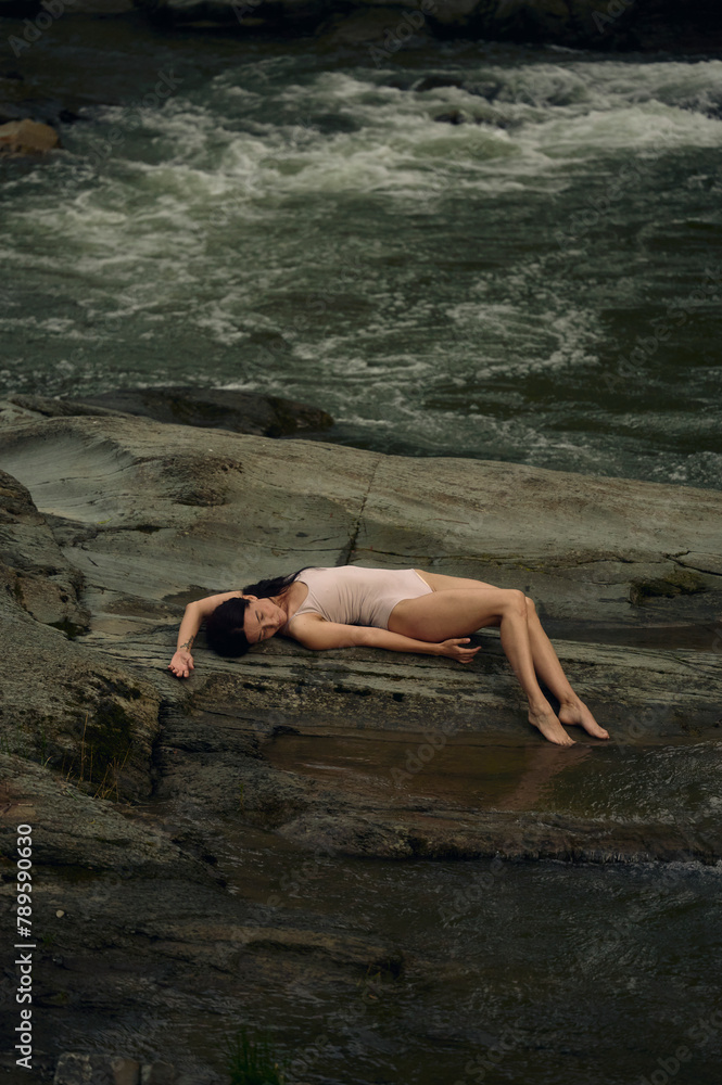 woman lying on a stone near the river woman lying on a stone near the river