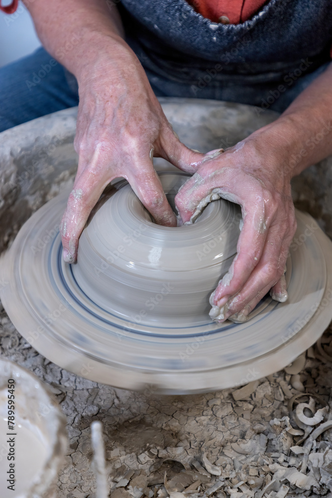 Potter's hands throwing a bowl on a pottery wheel Potter's hands throwing a bowl on a pottery wheel