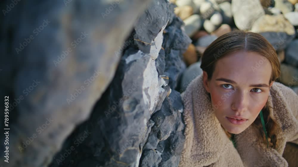 Fashion girl resting beach posing at stones closeup. Dreamy model with braids Fashion girl resting beach posing at stones closeup. Dreamy model with braids