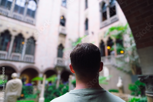 Tableau sur toile Man from behind admires beautiful green yard, travel destination concept