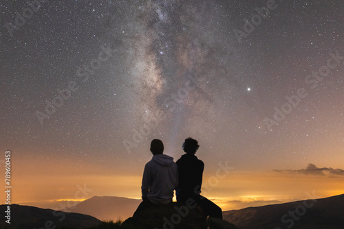Friends enjoying night sky in the mountains photo