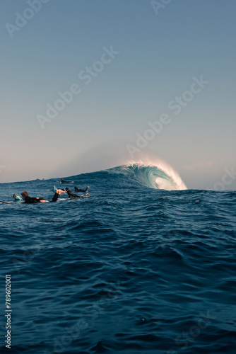 A group of surfers escaping from a giant wave. photo