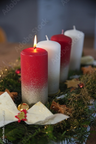 Adventsgesteck mit vier Kerzen - eine brennt
