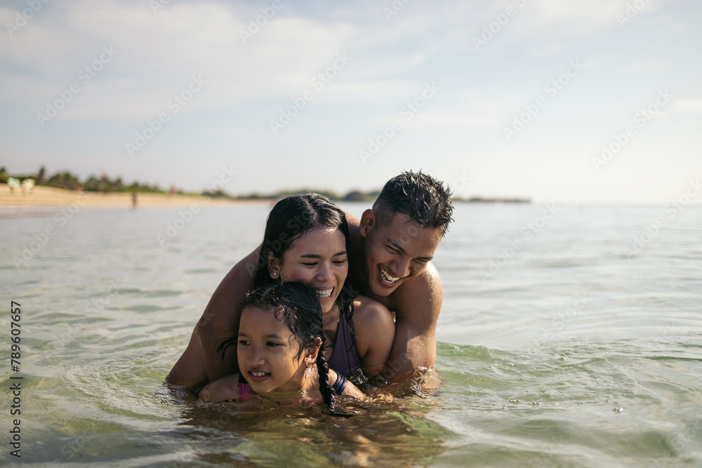 Asian family playing and having fun in the sea Asian family playing and having fun in the sea