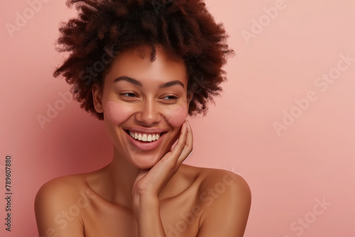 Against a neutral background, a 40-year-old woman removes makeup with finesse, displaying her glowing skin and joyful smile in a scene reminiscent of a cosmetics ad.