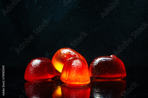 Glowing Red Candies on a Reflective Surface at Night