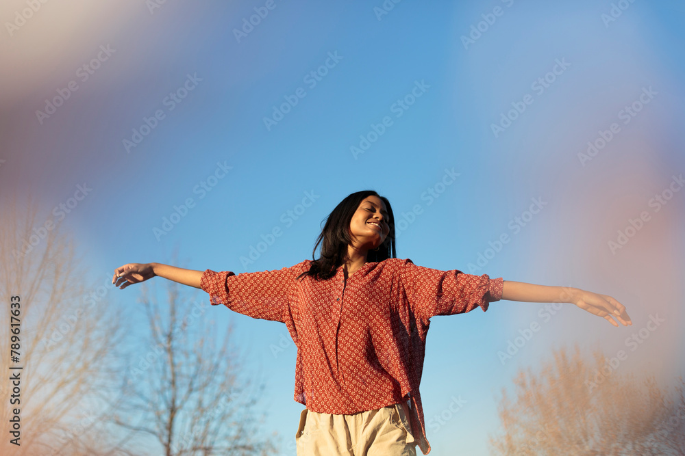 Attractive Happy Woman dancing over blue sky Attractive Happy Woman dancing over blue sky