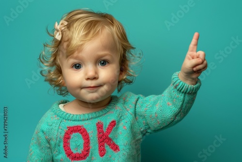 The child points his finger at the advertising space. The inscription OK on clothes. Background with selective focus