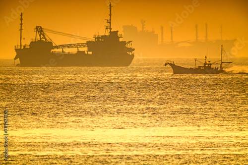 朝日を浴びる海で漁場へ向かう漁船20240414-2 photo
