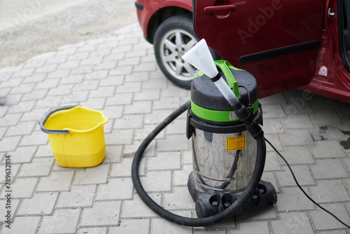 Professional extraction vacuum cleaner with car in background